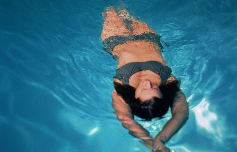 Kvinna simmar i poolen